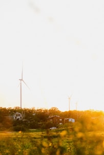 A vibrant village landscape at sunrise with solar panels and wind turbines blending into nature