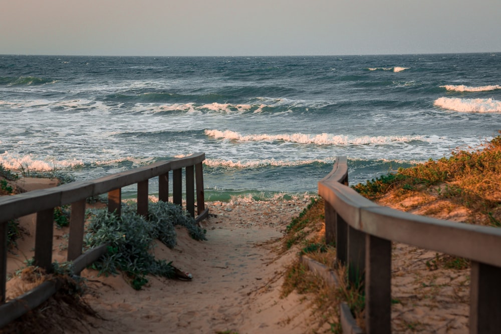 brown wooden fence on seashore during daytime