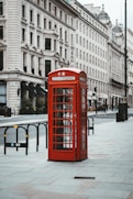 red telephone booth near white concrete building during daytime