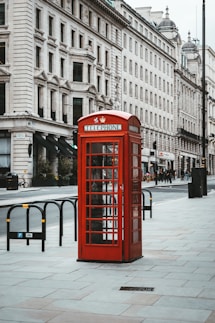 red telephone booth near white concrete building during daytime