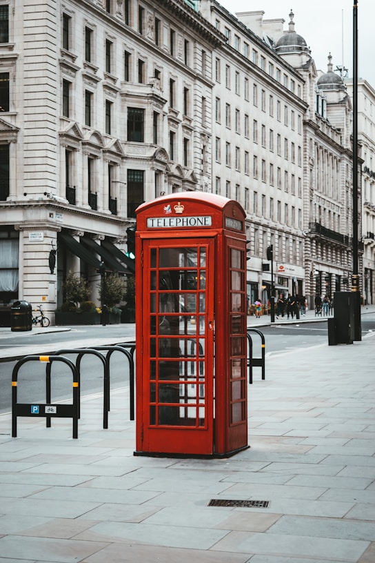 red telephone booth near white concrete building during daytime