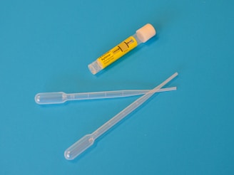 white ballpoint pen beside yellow and white plastic tool