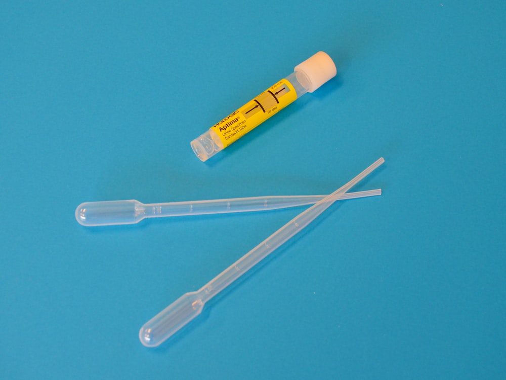 white ballpoint pen beside yellow and white plastic tool