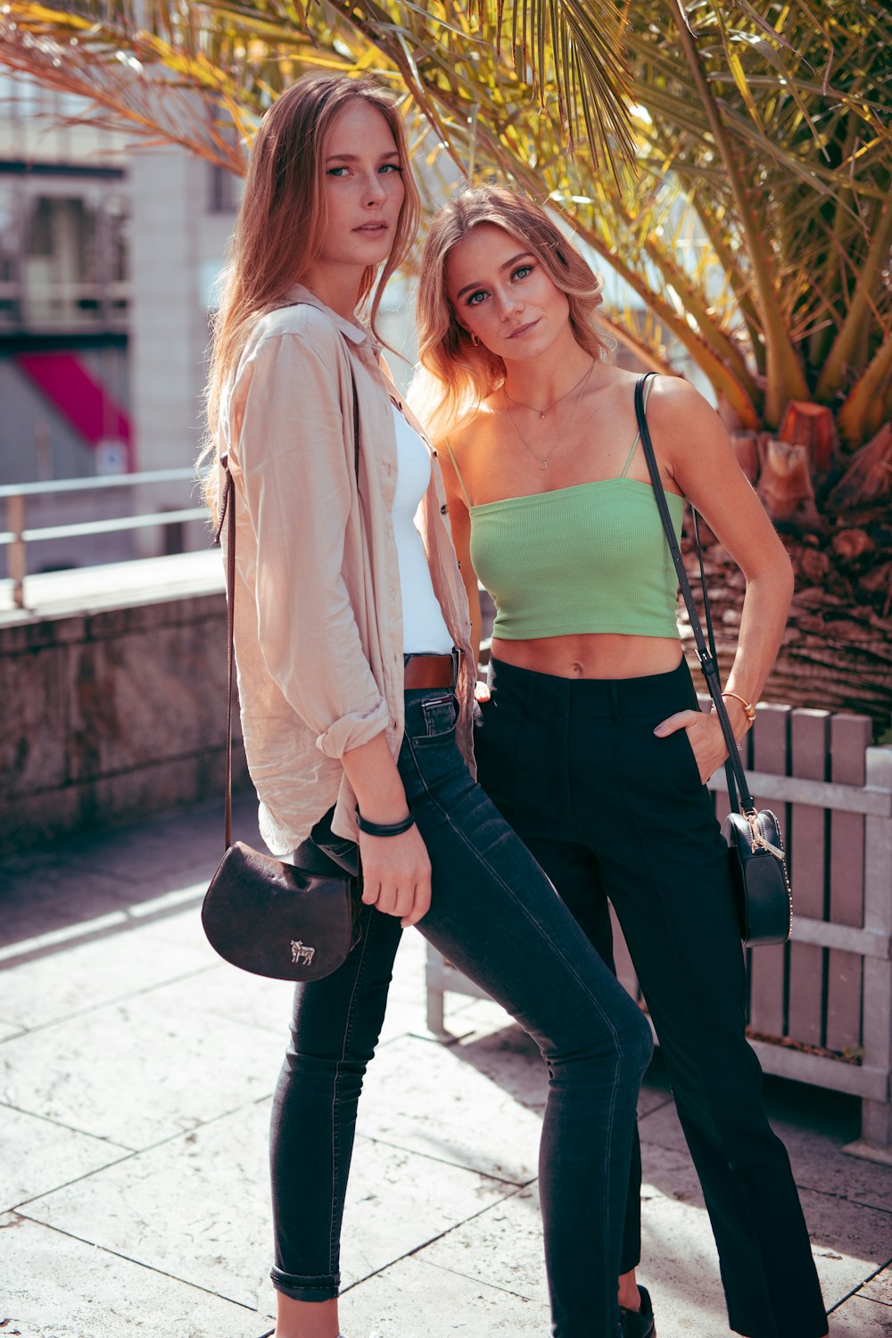 Femme en chemise à manches longues blanche et jean en jean bleu tenant un sac en cuir noir