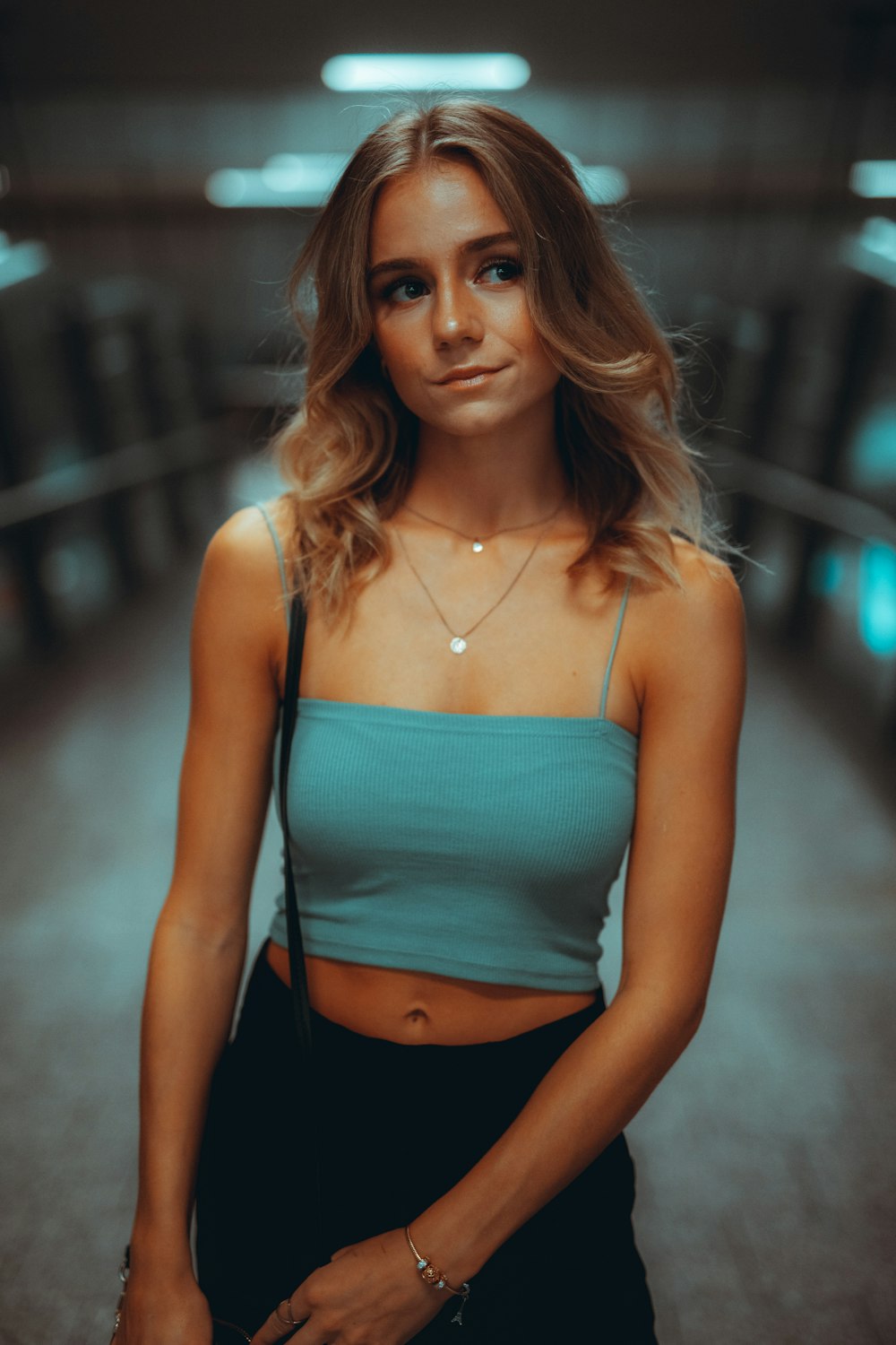 woman in teal spaghetti strap top and black bottoms