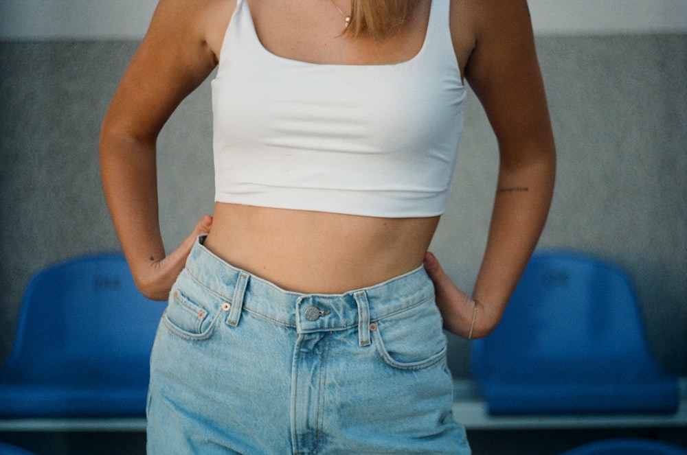 Mujer con camiseta blanca sin mangas y jeans de mezclilla azules