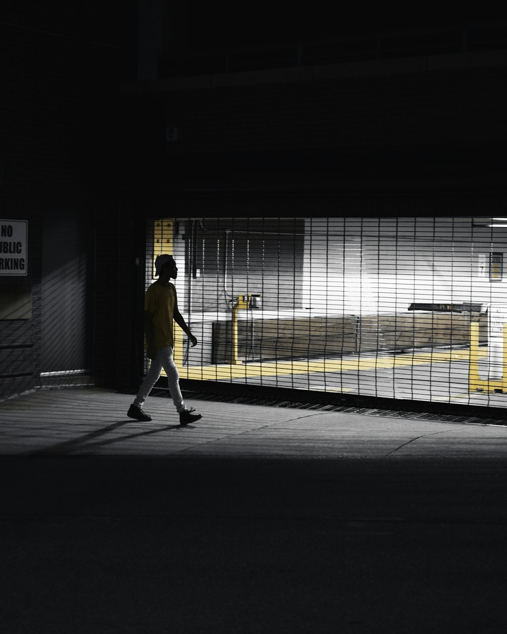 man in yellow jacket walking on sidewalk during daytime