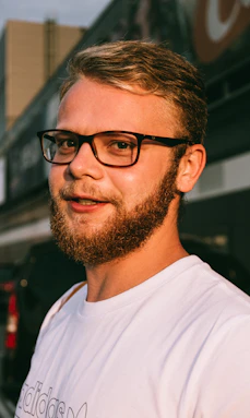 man in white crew neck shirt wearing black framed eyeglasses