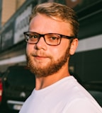 man in white crew neck shirt wearing black framed eyeglasses