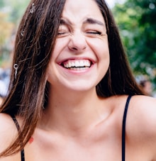 woman in black spaghetti strap top smiling