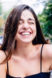 woman in black spaghetti strap top smiling