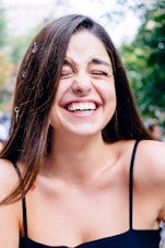 woman in black spaghetti strap top smiling