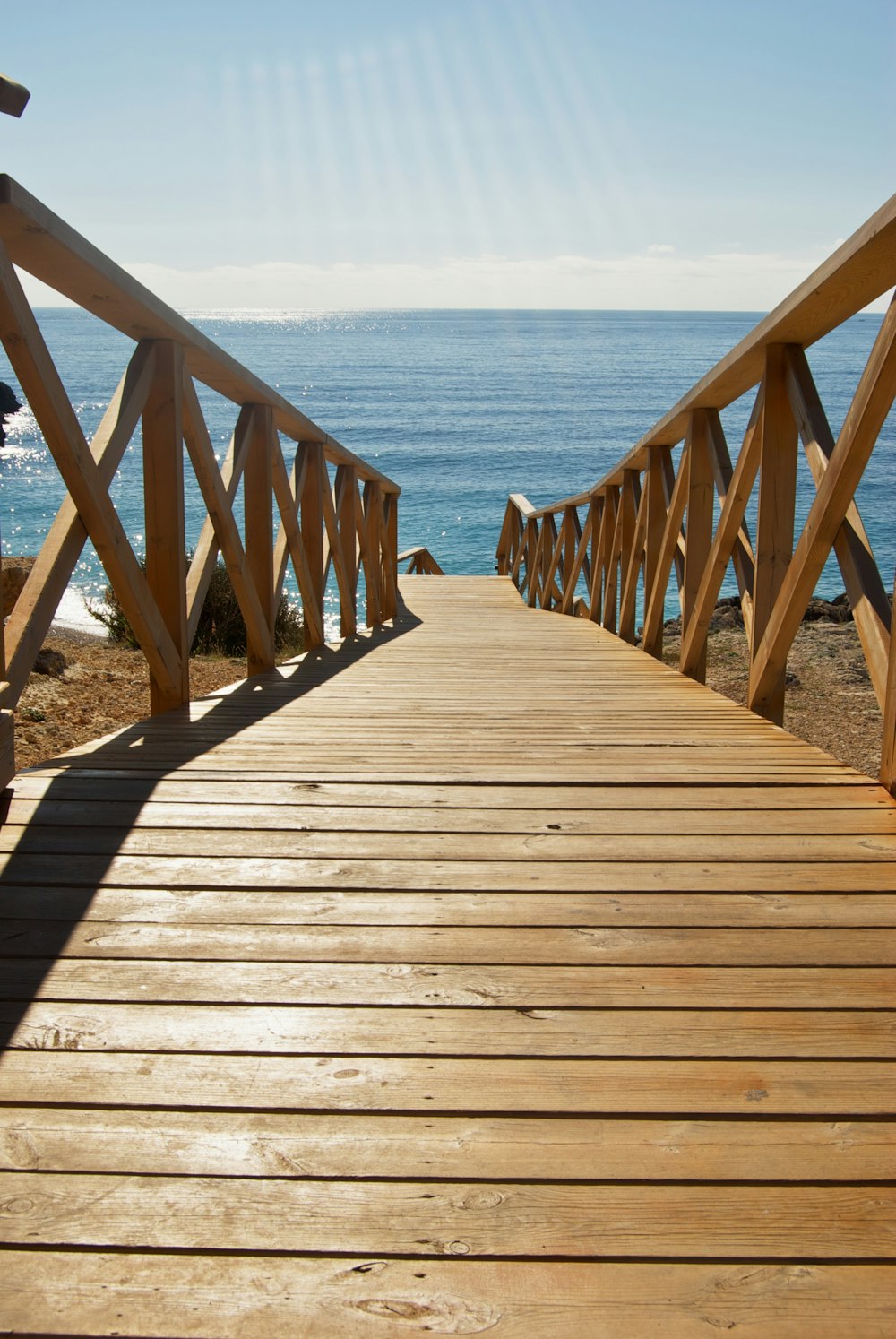 brown wooden bridge over the sea during daytime