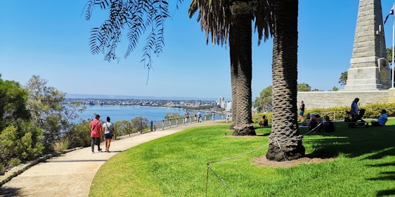 A vibrant riverside park in Culiacán with families enjoying walking paths and lush greenery under a bright sky.