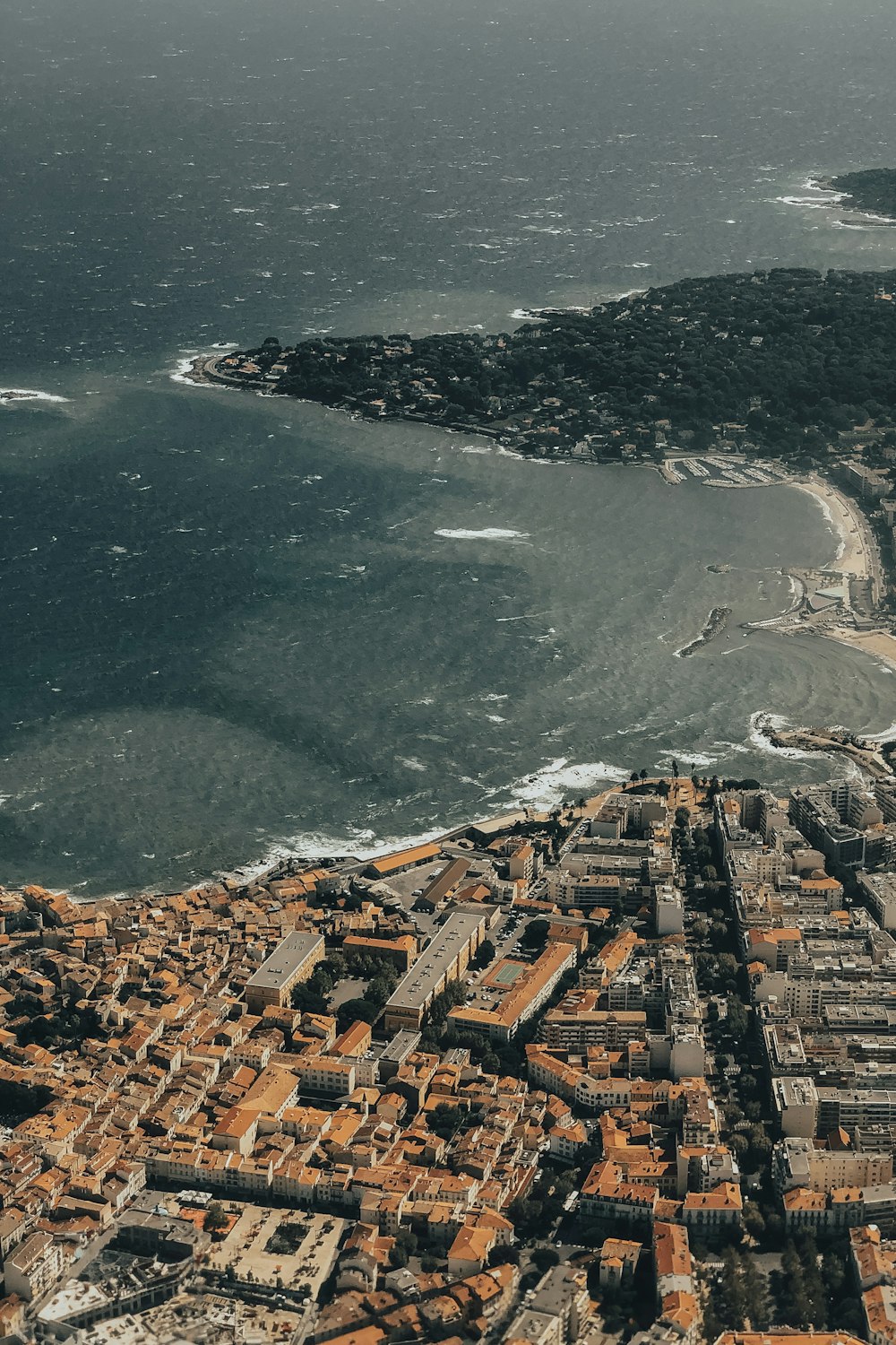 aerial view of city buildings near body of water during daytime