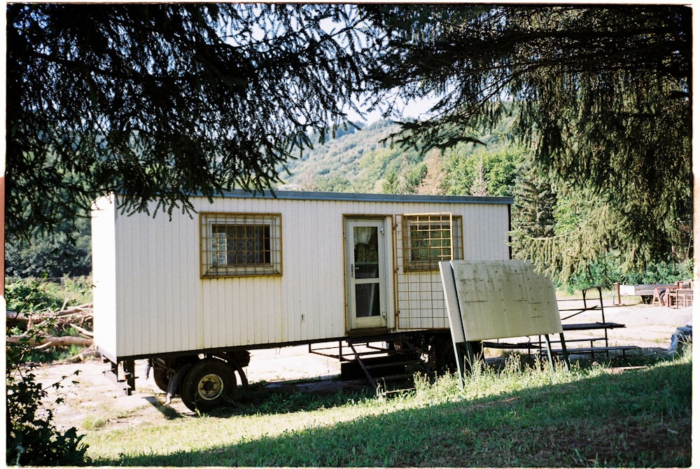 white wooden house near green trees during daytime