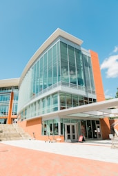 people walking on sidewalk near glass building during daytime