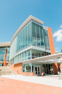 people walking on sidewalk near glass building during daytime