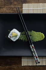 white and green sushi on black table