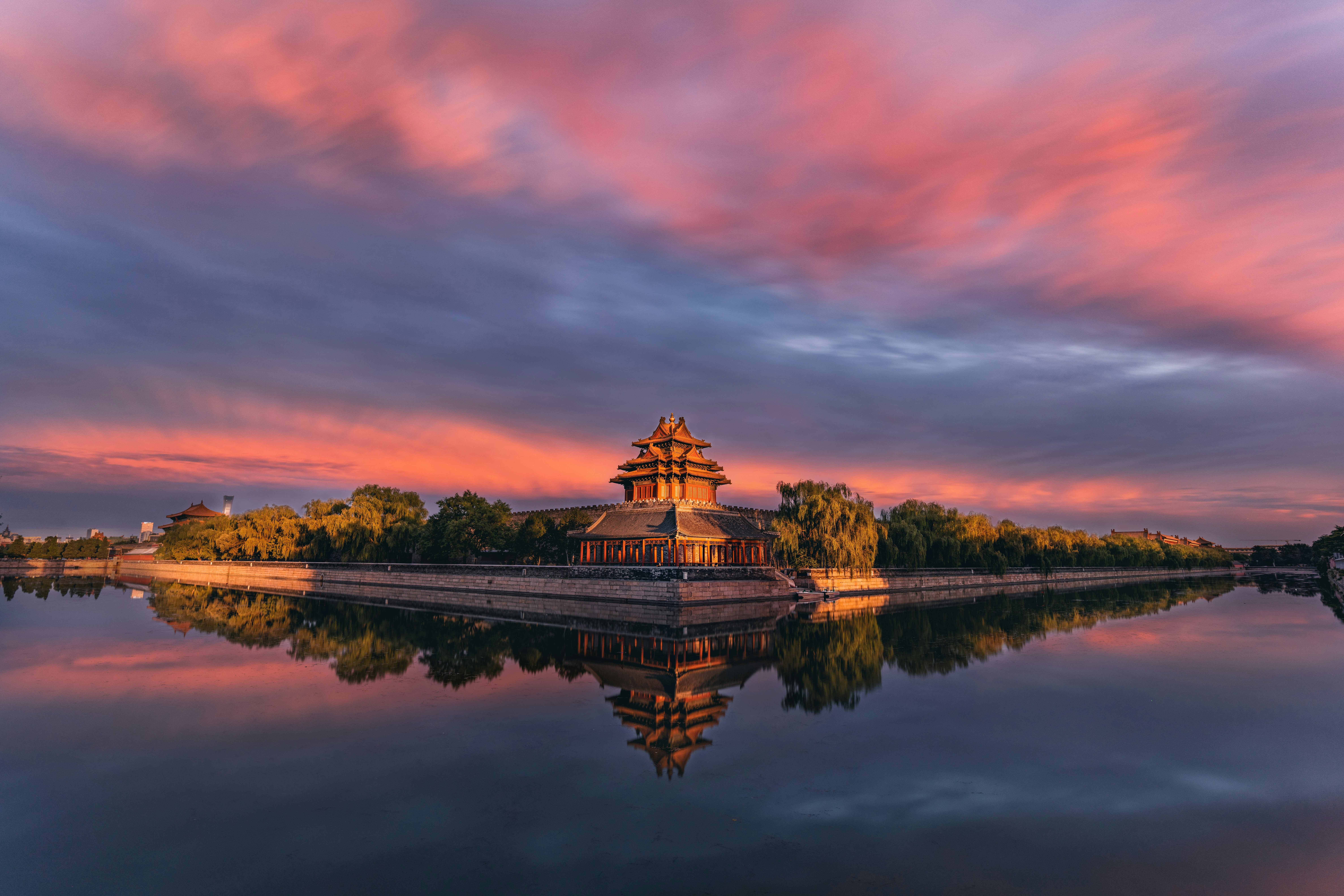 brown and white temple near body of water during sunset