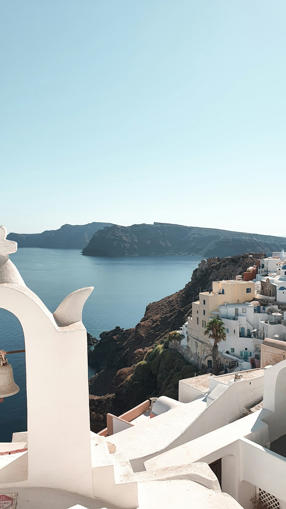 white concrete building on brown rock formation near body of water during daytime