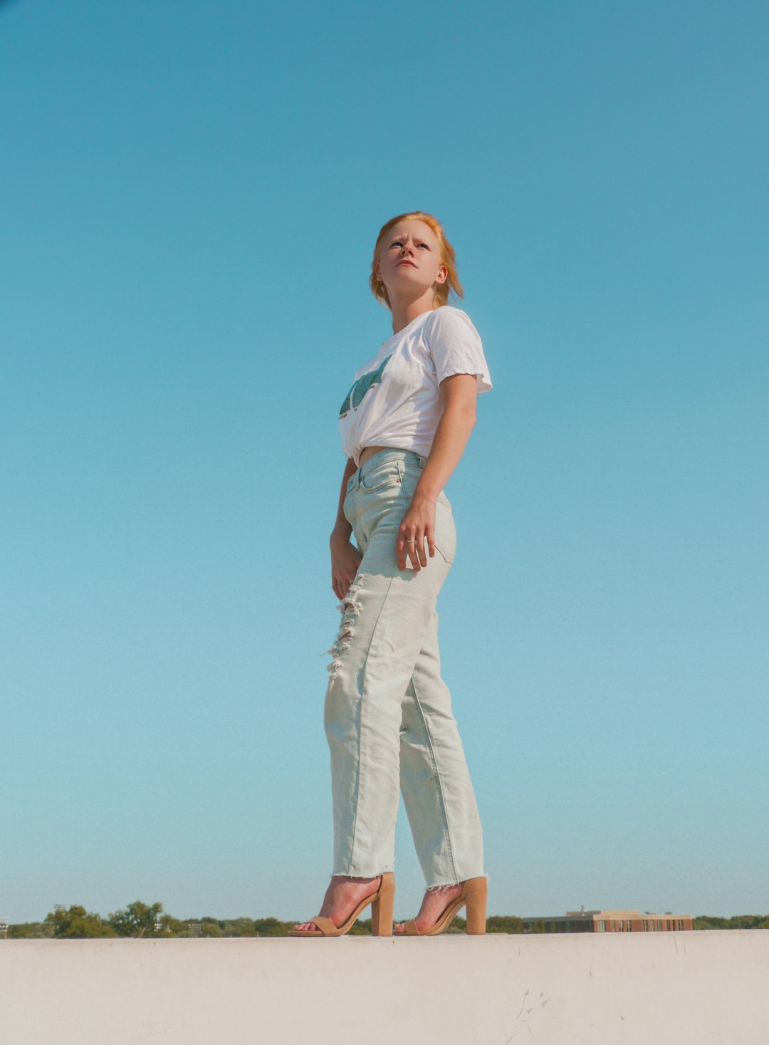 man in white t-shirt and beige pants standing under blue sky during daytime