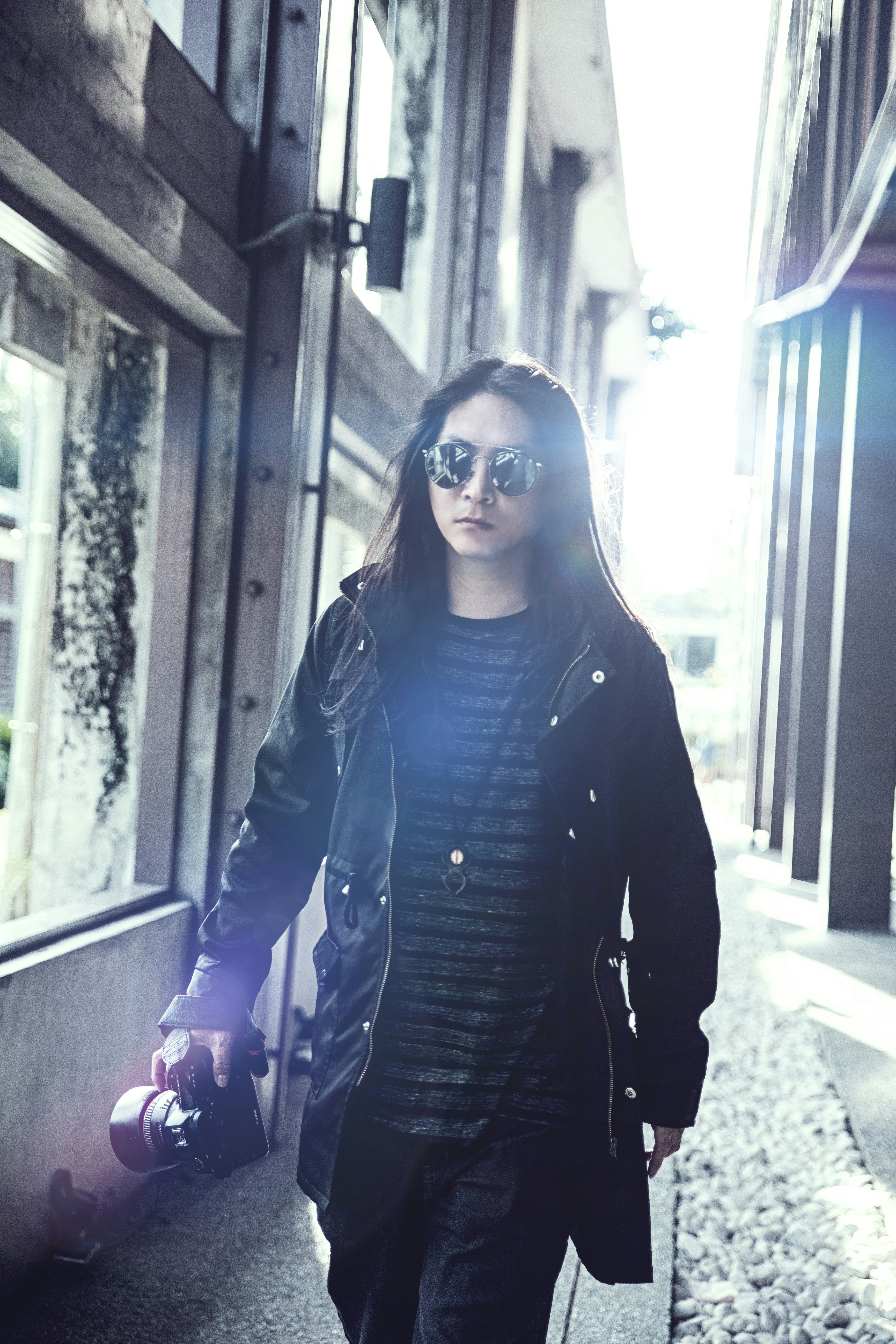 Woman in black leather jacket standing beside window during daytime ...