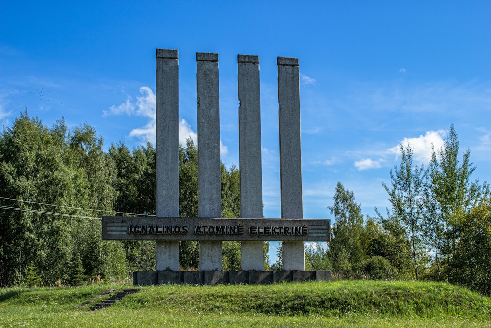 gray concrete pillar on green grass field during daytime