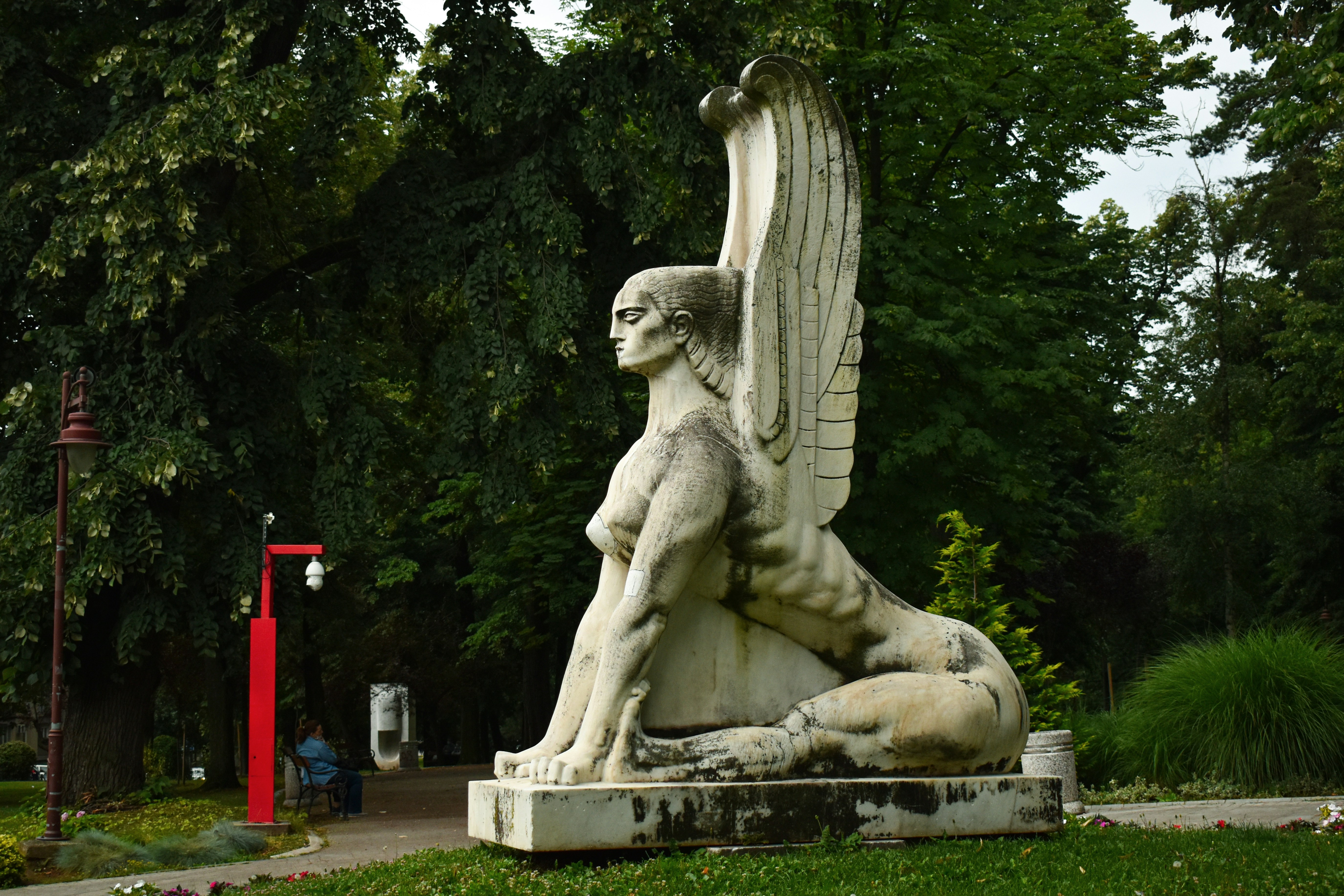 gray concrete statue near green trees during daytime