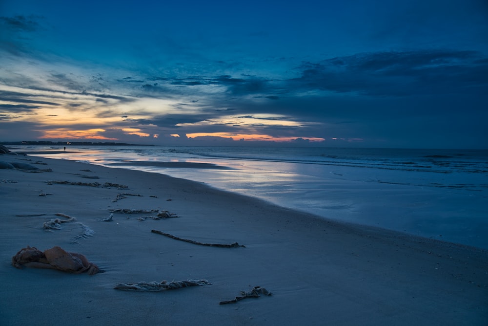 sea waves crashing on shore during sunset