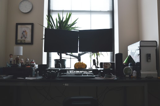 black flat screen computer monitor on brown wooden desk