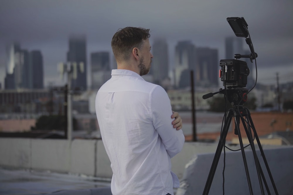 man in white long sleeve shirt standing in front of camera