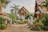 A picturesque courtyard is surrounded by traditional Thai architecture, featuring ornate carvings and roof designs. Lush greenery, including palm trees and various plants, adds to the serene ambiance. Decorative statues are placed throughout the area, and there is a sense of calm and spiritual tranquility.