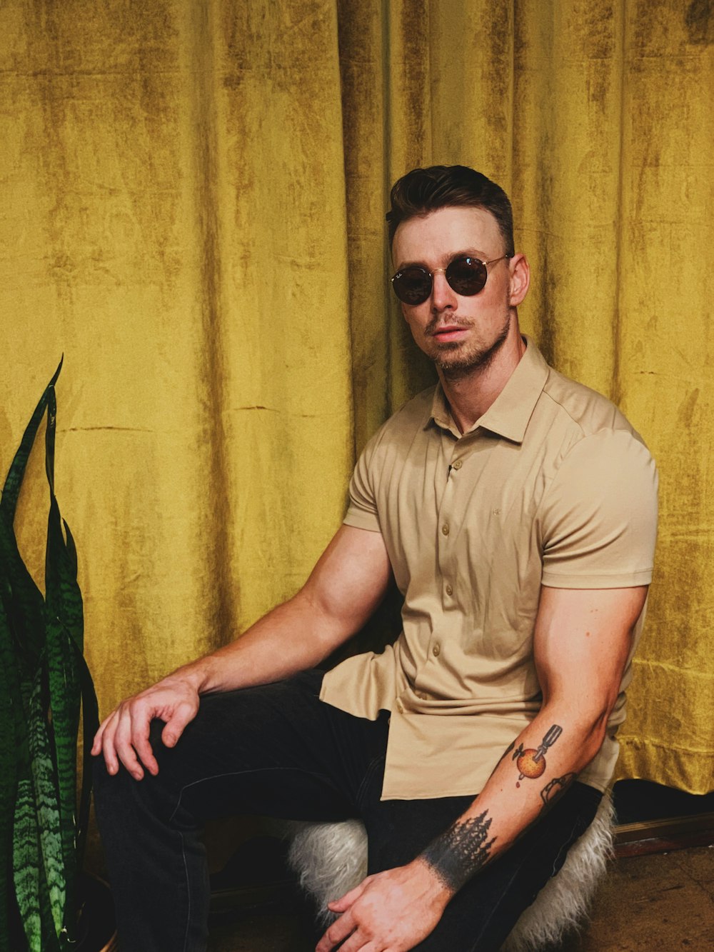 man in brown button up shirt and black pants sitting on chair