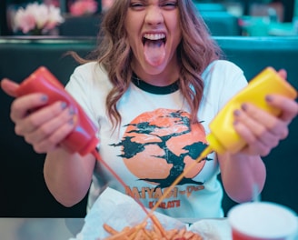 woman in white and red mickey mouse crew neck t-shirt holding french fries