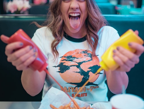 woman in white and red mickey mouse crew neck t-shirt holding french fries