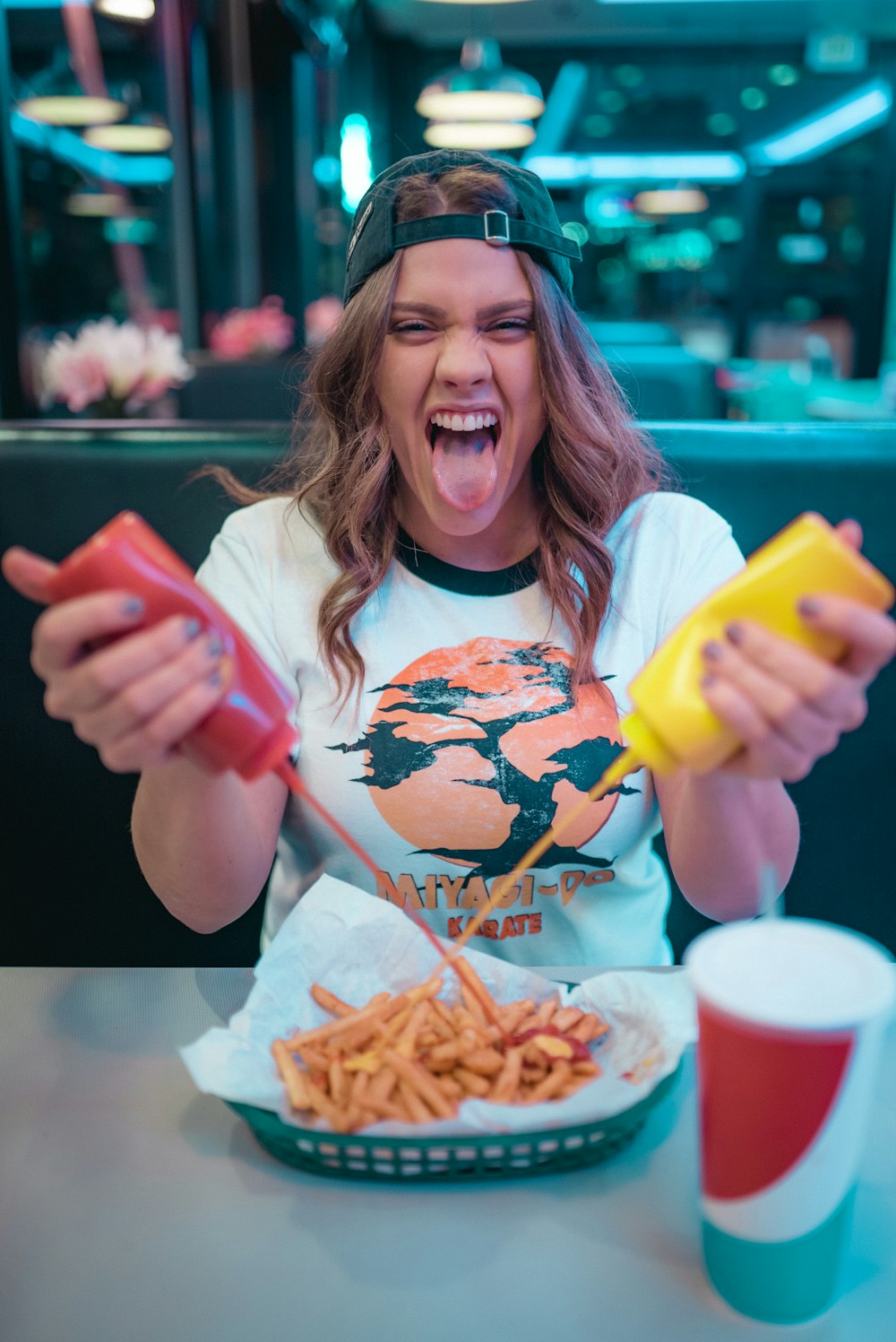 Mujer con camiseta blanca y roja de cuello redondo de Mickey Mouse sosteniendo papas fritas