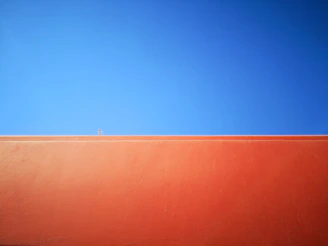 Close-up of a freshly painted orange exterior wall with clean edges and vibrant color.