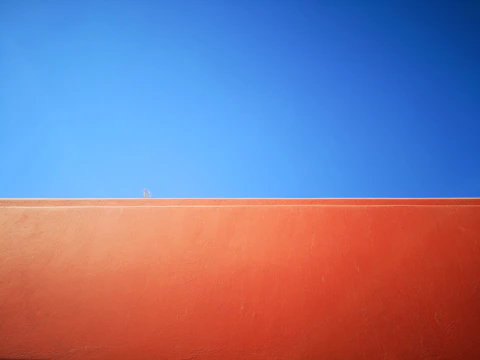Close-up of a freshly painted orange exterior wall with clean edges and vibrant color.