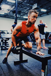 A dedicated coach guiding a client through weightlifting exercises in our vibrant orange-themed gym.