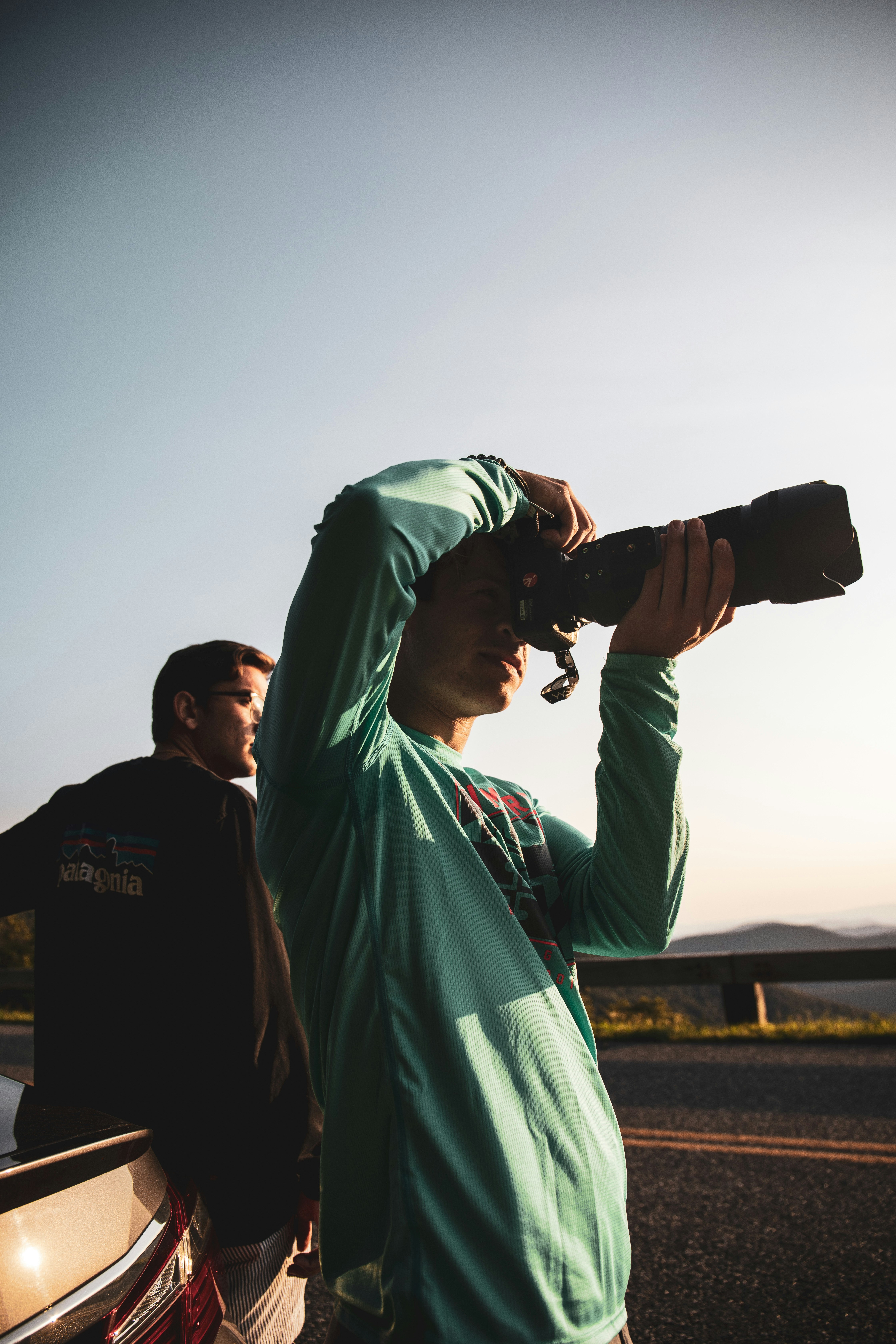 man in blue jacket holding black dslr camera