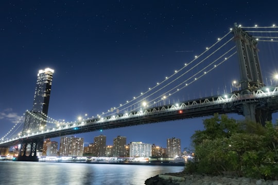 lighted bridge over river during night time in Brooklyn Bridge Park United States