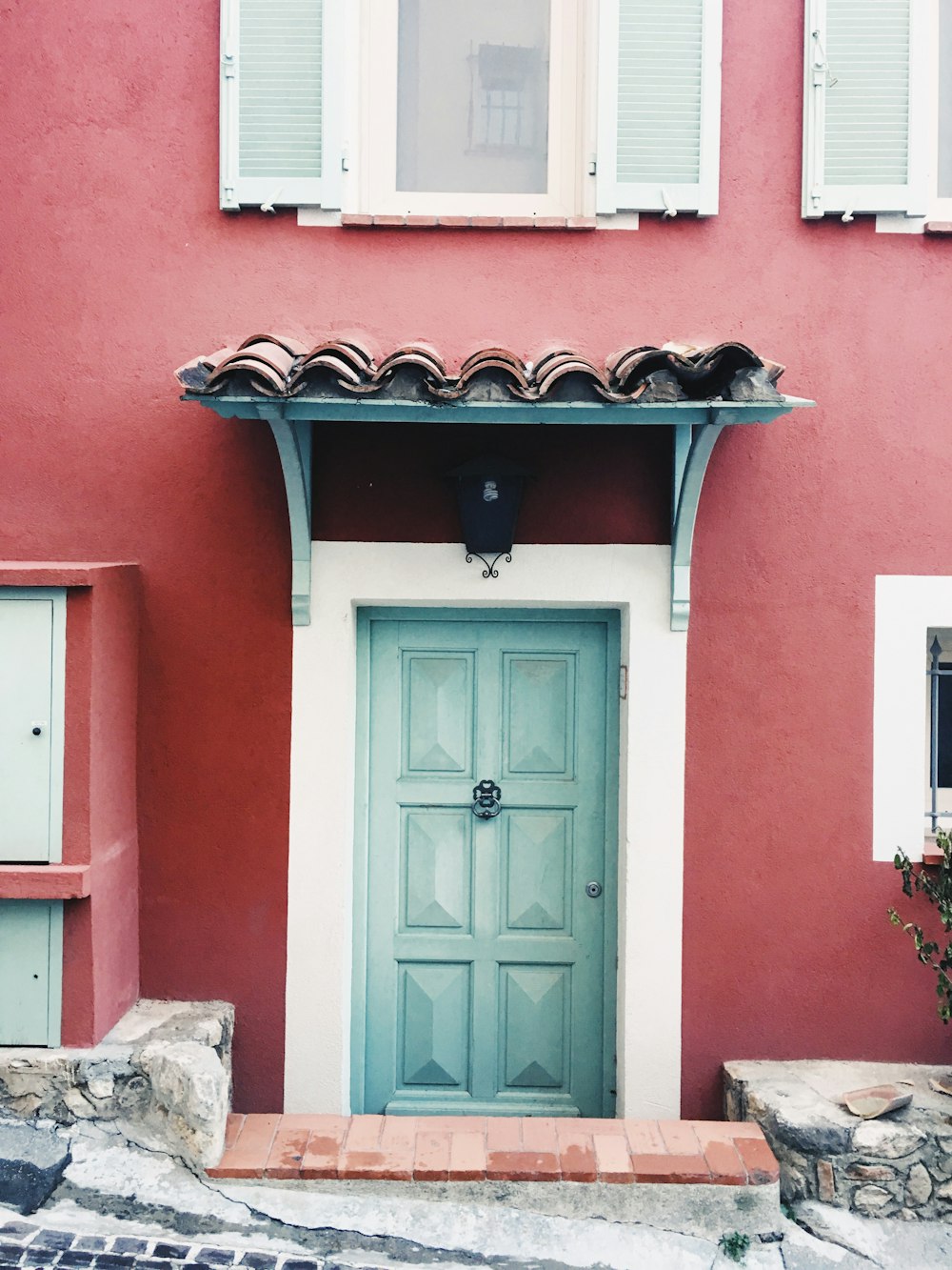 Porte en bois blanc sur maison en béton rouge