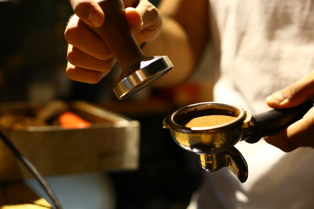 person holding silver steel cup