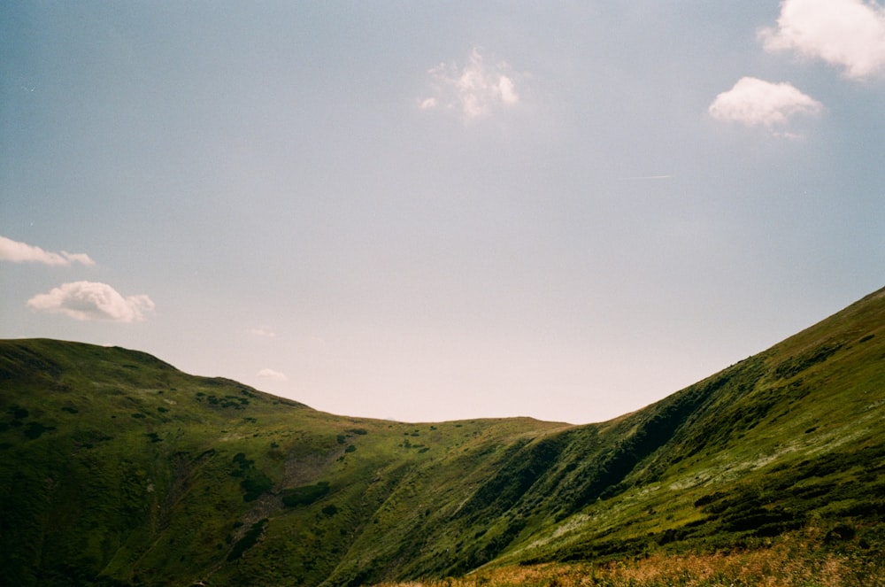 green mountain under white clouds during daytime