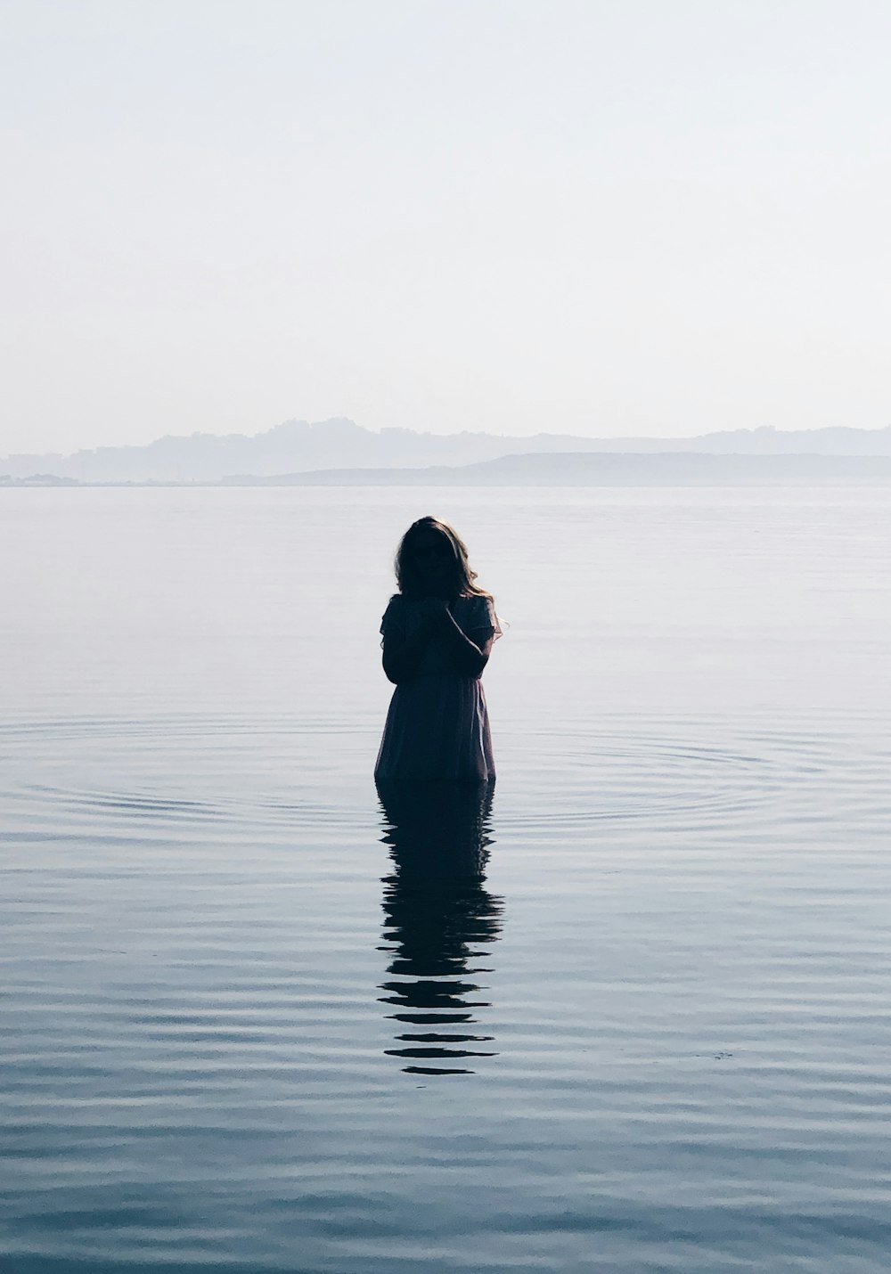 woman in black dress standing on water