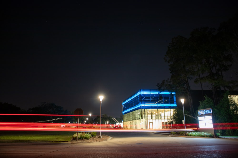 blue and white building near green trees during night time