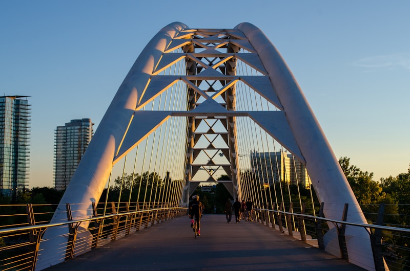 Cyclist riding across the Humber Bay Arch Bridge in Toronto during sunrise