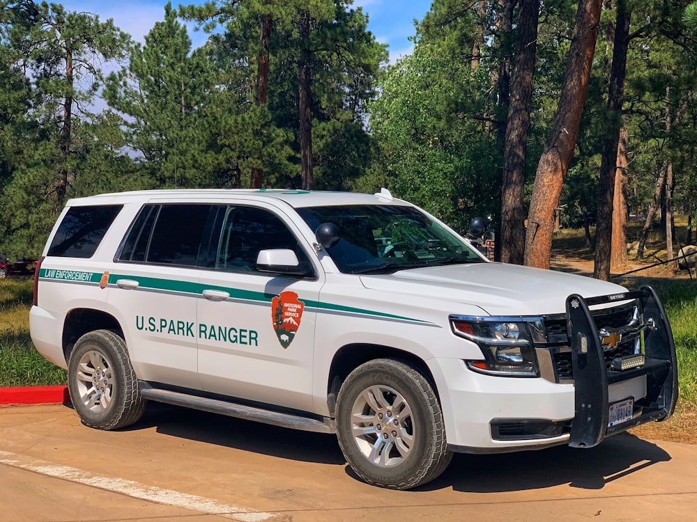 SUV Honda blanco estacionado cerca de árboles verdes durante el día