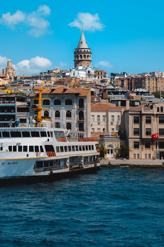 white boat on body of water near concrete buildings during daytime in Galata Tower Turkey